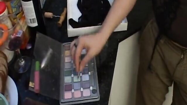 Crossdresser applying makeup in messy room, amateur prep