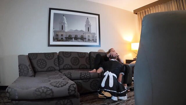 Sissy maid in black frilly uniform worships headmistress feet on couch