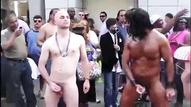 Nude pale bald guy and black muscular hunk jerking off publicly for Folsom crowd