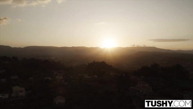 Stunning sunset view over hills with TUSHY logo, anal tease vibe