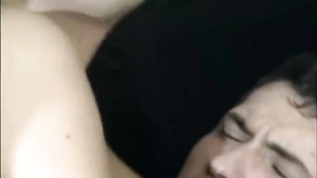 Closeup of woman smothering man's face with pale tits in intimate bedroom play