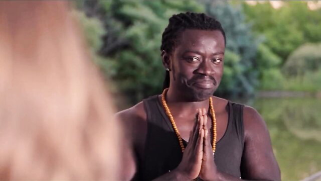 Eveline Dellai with black yoga instructor Freddy Gong praying outdoors