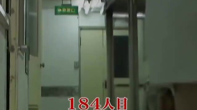 Asian medical worker in uniform stalked in hospital hallway by creep