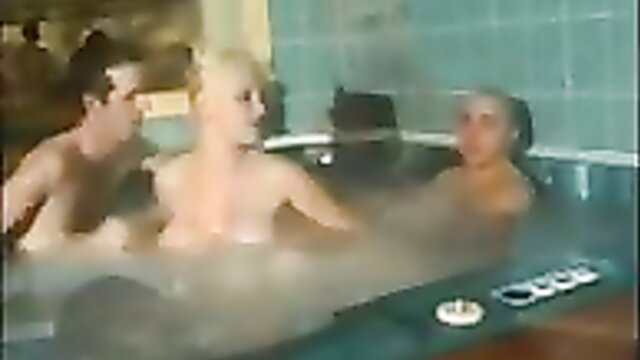 Blonde babe naked in steamy hot tub with two nude guys in swinger orgy