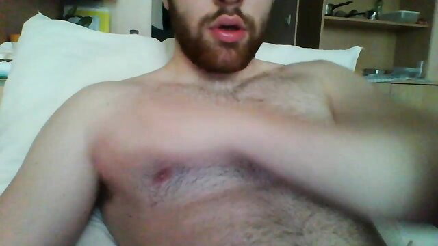 Bearded hairy muscular guy stroking cock on bed in amateur gay solo