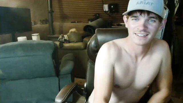 Nude twink Ethan smiling shirtless in chair, amateur gay thumbnail