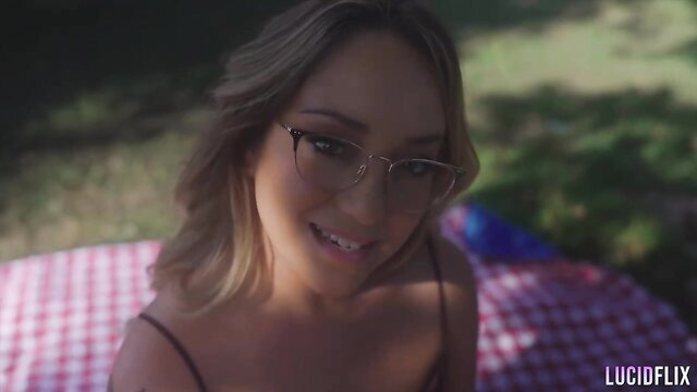 Remy LaCroix smiling in top on picnic blanket outdoor scene
