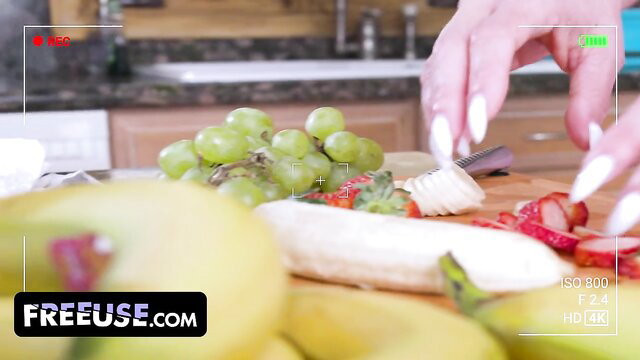 Freeuse stepmom slicing fruit with grapes, banana, strawberries on counter