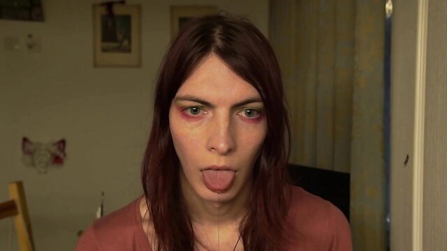 Redhead with blank stare sticks out tongue drooling closeup