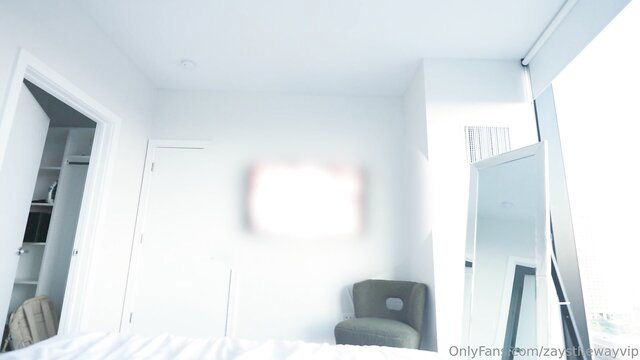 Keke Bhad in minimalist white bedroom with bed and mirror