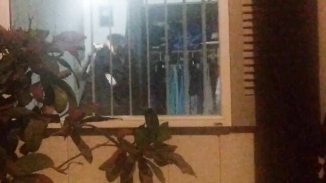 Vixen at barred window with plants, teasing in StagVixen hotwife scene