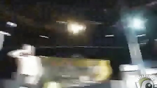 Blurry night scene with yellow machinery and white structures, music rocks