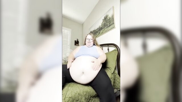 BBW with huge belly sits on bed in weigh-in video