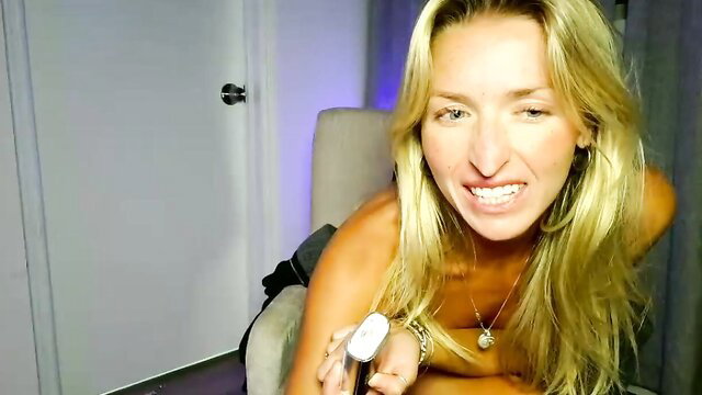 Emmybunnyx tanned blonde camgirl nude grin holding toy closeup