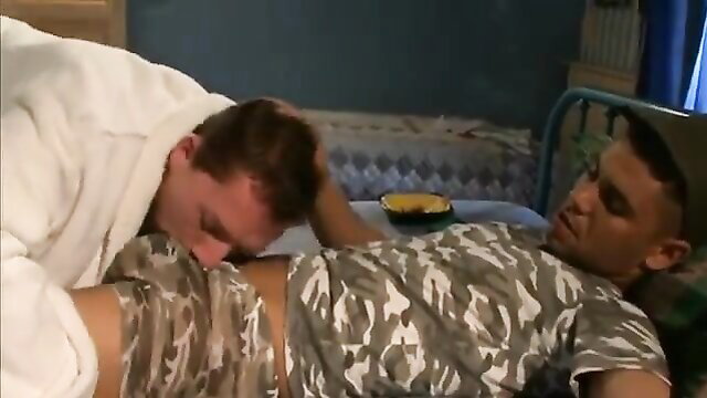 Two hot men in bed, one sucking cock in intimate gay duo scene