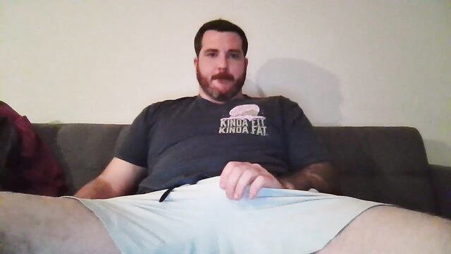 Bearded muscular daddy in tight shorts bulging on couch, amateur gay thumbnail