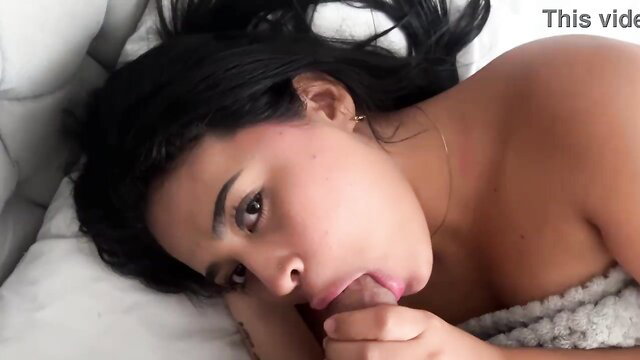 Latina beauty sucking cock passionately in bed on white sheets