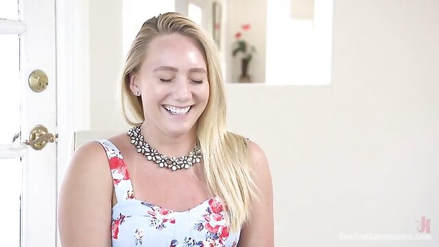 Blonde smiling in floral dress, teasing charm