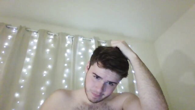 Hot college dad bod guy shirtless flexing arm in bedroom with fairy lights