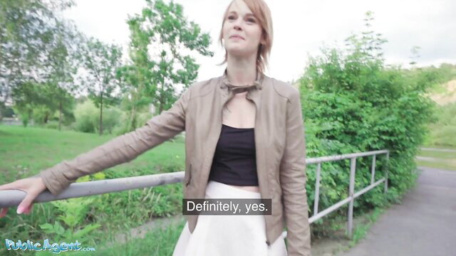 Redhead Ariela Donovan in leather jacket and skirt on public bridge