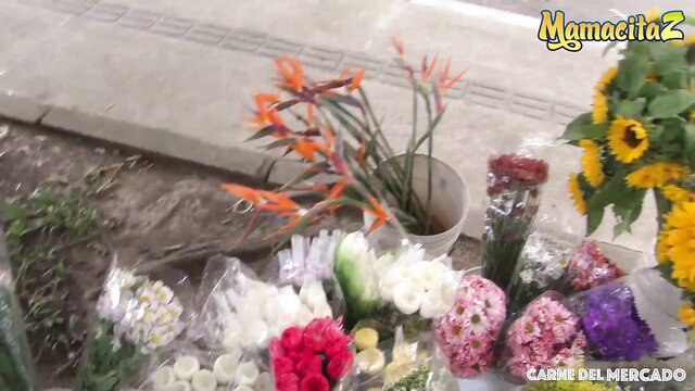 Flower market stall with vibrant roses, sunflowers, birds of paradise