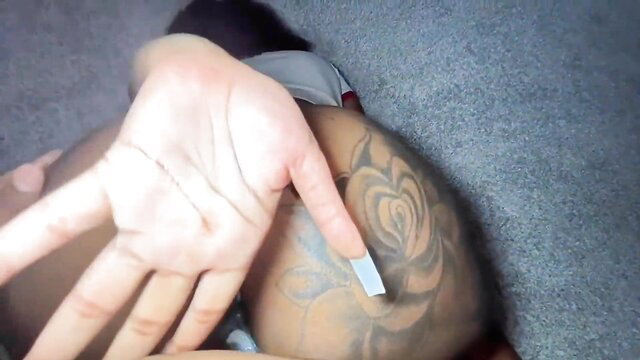 Black woman with long nails traces rose tattoo on man's butt in hot tease