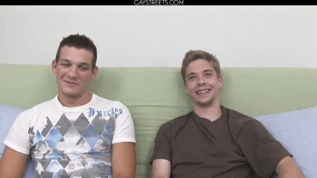 Jayce and Sean smiling on bed in tees, hot gay duo thumbnail