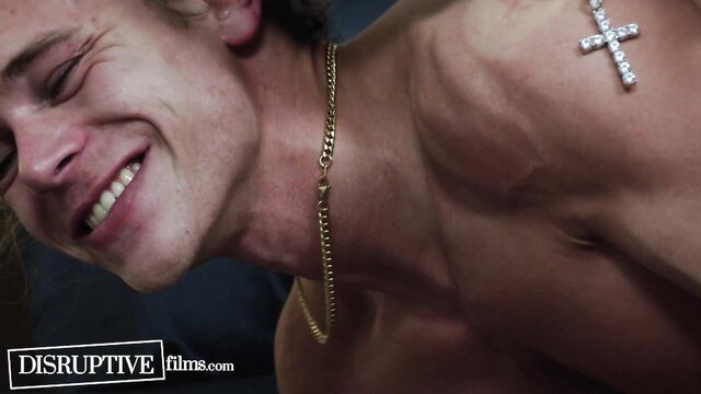 Roman Todd smiling shirtless with gold chain and diamond cross necklace