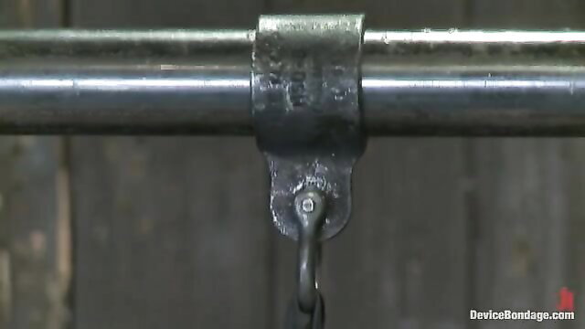 Blonde bound in metal pipe restraints with chain, BDSM setup