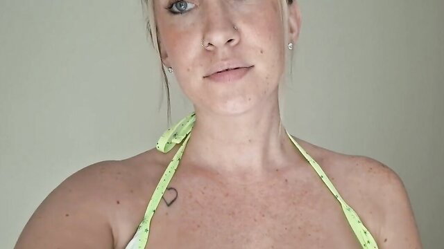 Blonde busty neighbor in yellow bikini top, teasing cleavage closeup