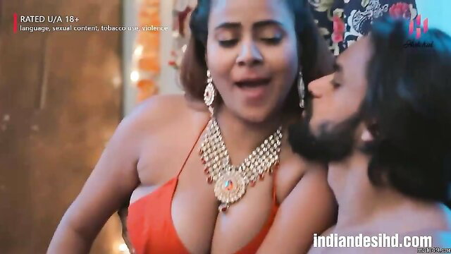 Indian couple in hot kissing scene, busty woman in red cleavage top