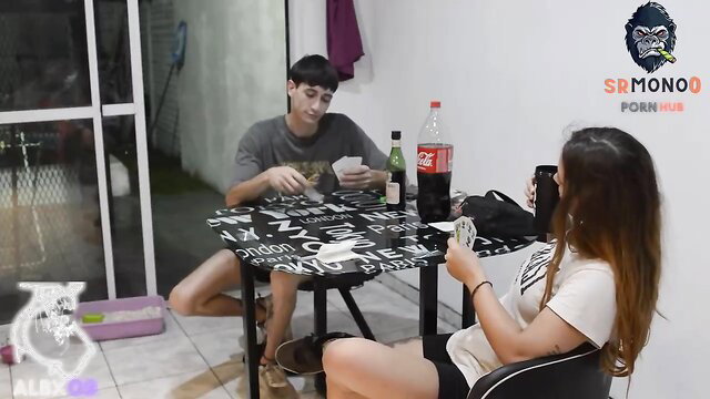 Amateur Latina couple playing cards at table in casual clothes