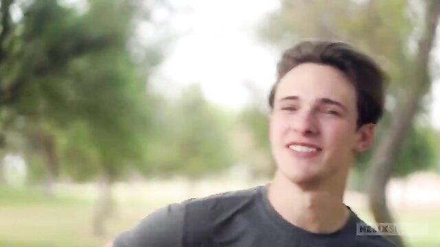 Smiling young white twink outdoors in gray tee, soft amateur tease