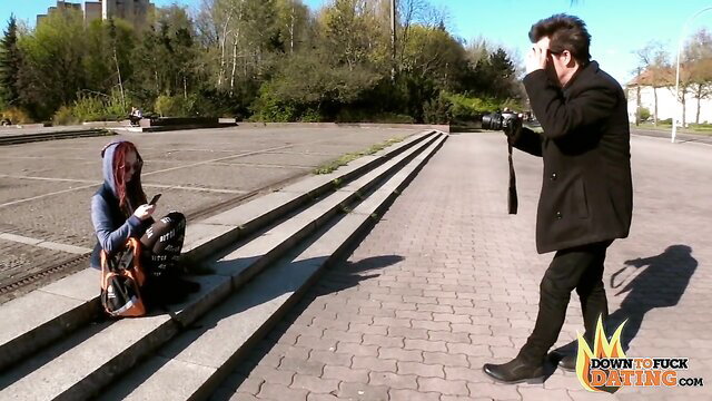 Jezzi Cat in pigtails kneels for hipster guy photographing her outdoors