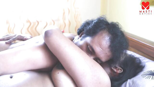Indian couple cuddling nude in bed, intimate embrace