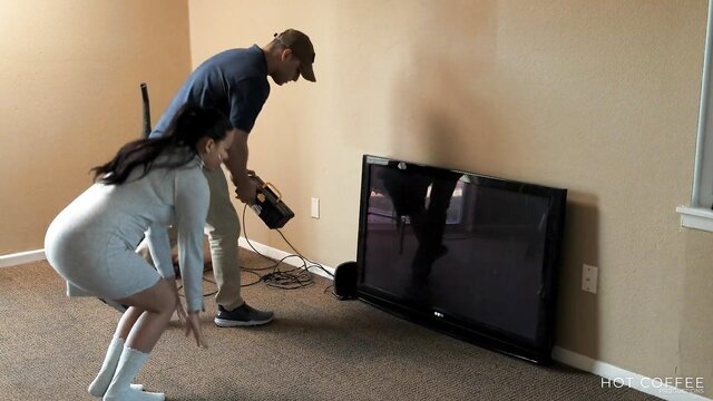 Asian Jolla squats in tight skirt as Mark Stones plugs cable behind her