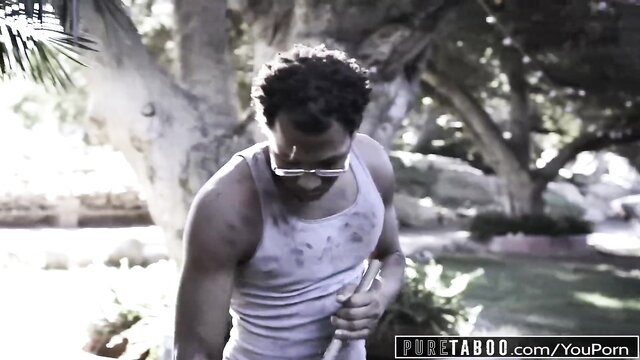 Muscular black man in dirty tank top holds object outdoors, Pure Taboo IR scene