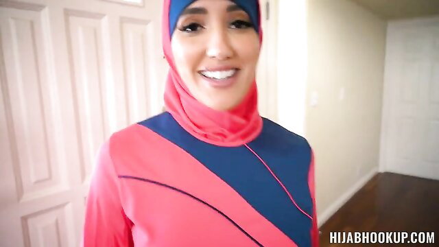 Arab hijab girl in tight sporty outfit smiles seductively