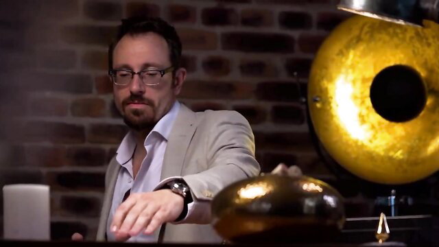 Lena Nitro blonde in suit poses by golden gong in Wolf Wagner video