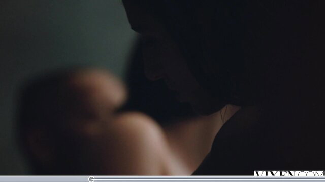 Blurry closeup of woman breastfeeding baby in dim light