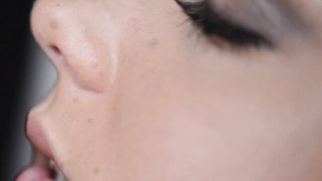 Closeup of beautiful woman's face with parted lips in lesbian tease