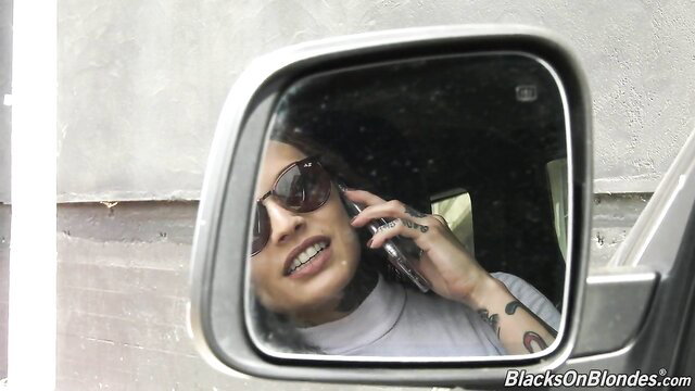 Vanessa Vega on phone in car, sexy tats and shades