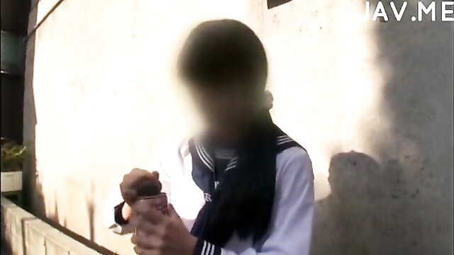 Blonde JAV schoolgirl in sailor uniform holding drink outdoors censored