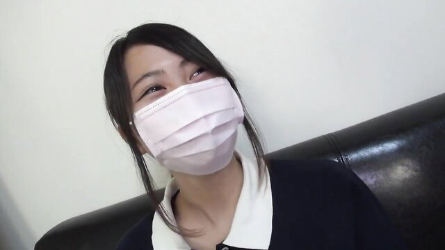 Cute Japanese girl in pink mask and schoolgirl uniform looking up teasingly