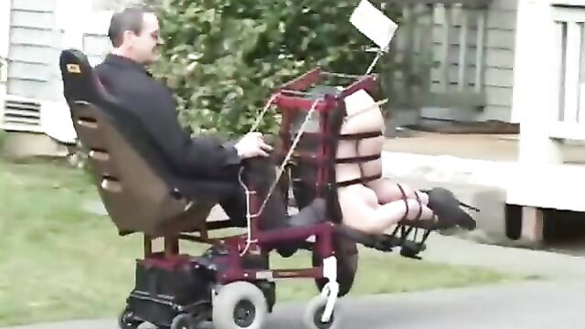 Man in wheelchair fucks bound BDSM slave's ass outdoors missionary