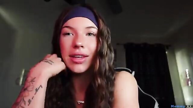 Mixed race tattooed beauty in headband teases breast implants