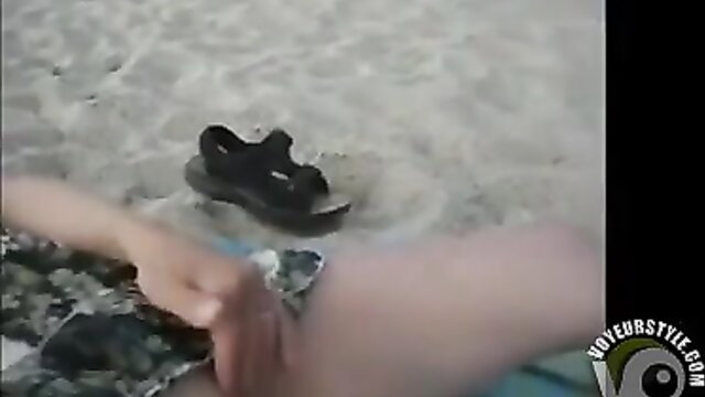 Woman rubbing shaved pussy on public beach, hand on clit closeup