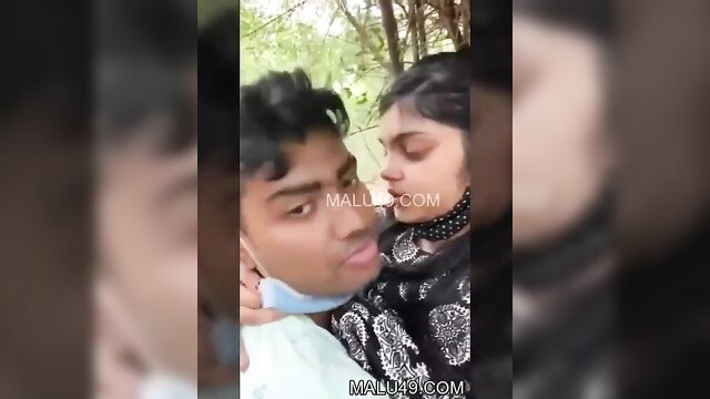 Indian couple passionately kissing outdoors in masks