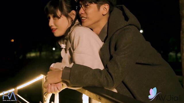 Hot Asian MILF in glasses cuddles with guy in hoodie at night