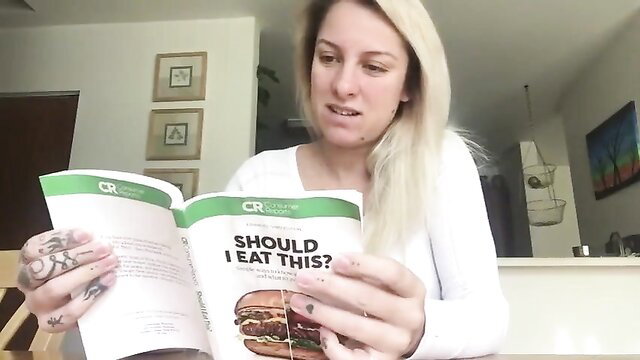 Blonde tattooed girl holds burger in 'Should I Eat This?' vore fetish book